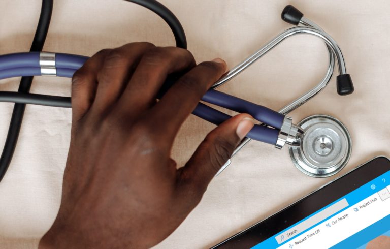 Hospital Employee With Stethoscope and a Tablet Running SharePoint
